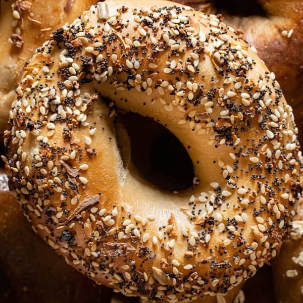 Close-up of a Henry Higgins Boiled Bagel, generously topped with poppy seeds and sesame seeds.